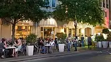 People sitting at tables near a street