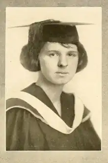 A young white woman with a bouffant bob hairstyle, wearing an academic cap and gown